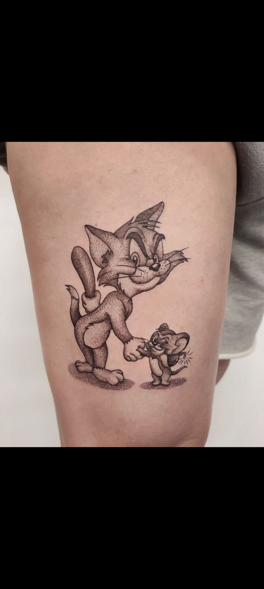 Tatuaje ilustrativo en puntillismo de Tom y Jerry chocando puños — estilo dotwork en Madrid · As de Picas Madrid