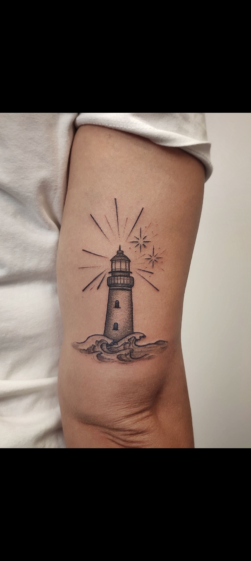 Tatuaje de faro marinero con olas y estrellas en línea fina — tatuajes línea fina Madrid · As de Picas Madrid