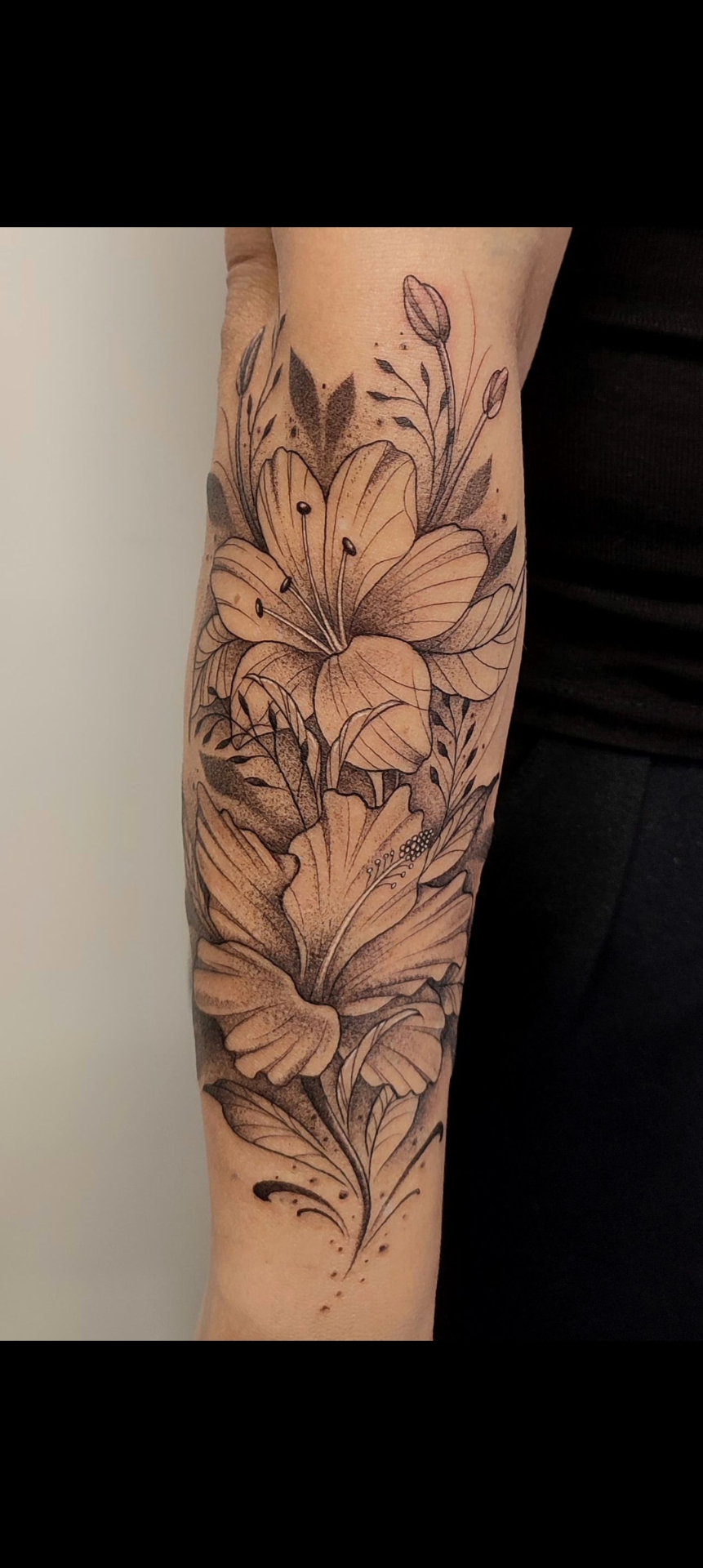 Tatuaje de línea fina y puntillismo con flores de lirio en el antebrazo — tatuajes línea fina Madrid · As de Picas Madrid