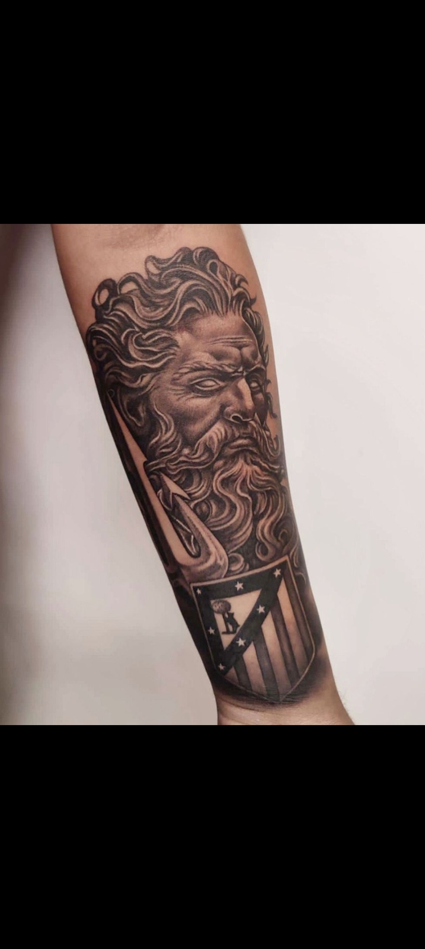 Tatuaje realista de Poseidón con escudo del Atlético de Madrid — estilo realismo en Madrid centro · As de Picas Madrid